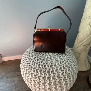 Elegant Brown Leather Handbag
9.5” L x 7” H Base width 4”
Gold hardware clasp
